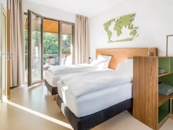 Schlafbereich einer Komfort-Maisonette mit zwei Betten und Zugang zur Terrasse